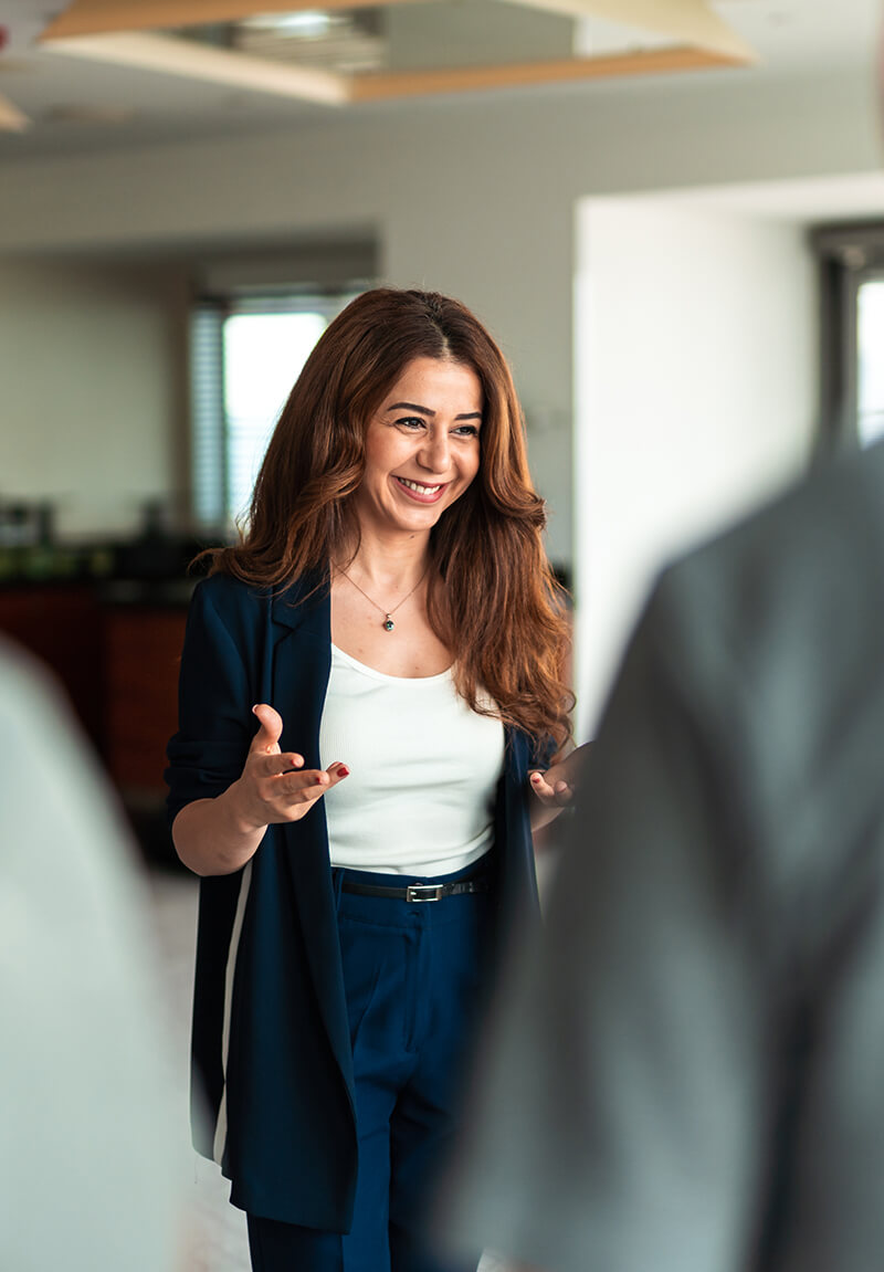A female Turkish corporate employee smiles at coworker