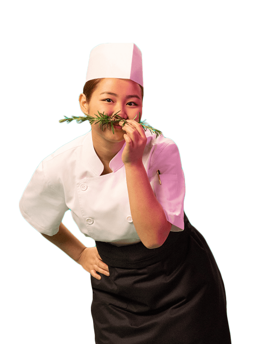 A chef leaning forward and enjoying the scent of a sprig of rosemary